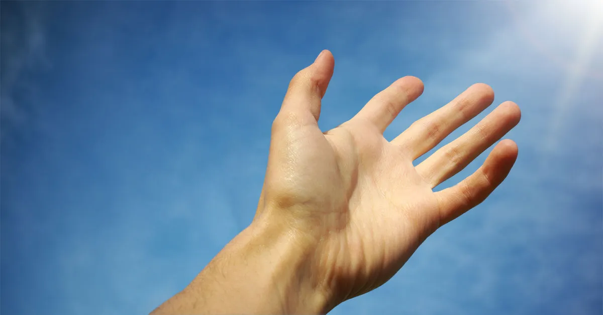 Person reaching toward light representing the search for truth